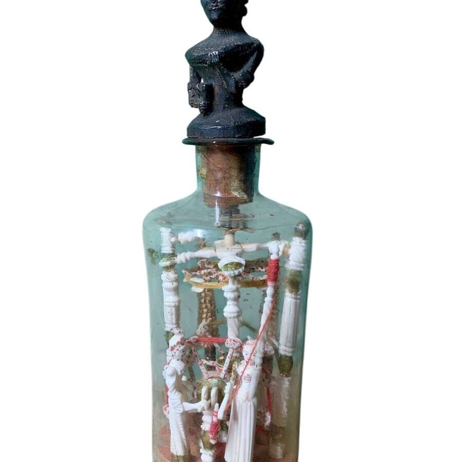A RARE P.O.W BOTTLE WHIMSEY WITH CARVED AFRICAN FINIAL