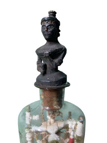 A RARE P.O.W BOTTLE WHIMSEY WITH CARVED AFRICAN FINIAL